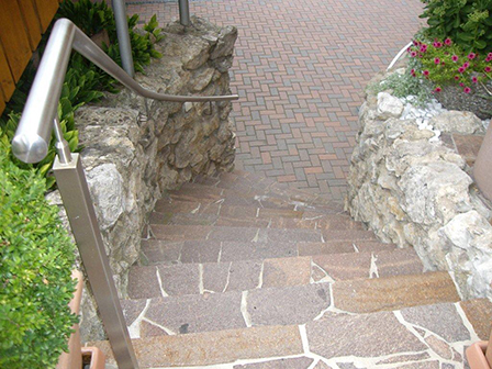 Bruchsteinmauer und Treppe mit Granitbruchbelag